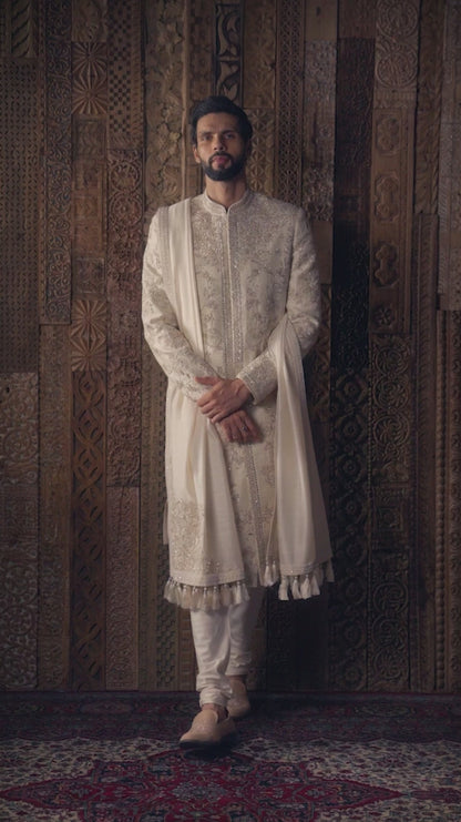 An almond beige raw silk sherwani featuring intricate tone-on-tone embroidery,
